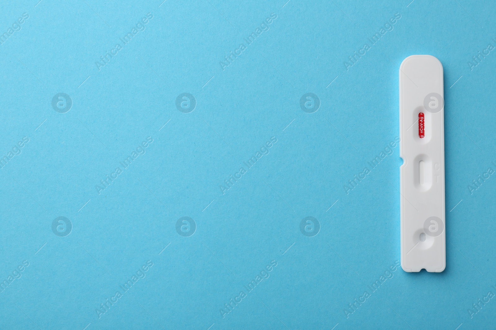 Photo of Disposable Covid-19 express test on light blue background, top view. Space for text