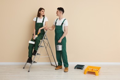 Photo of Young workers with painting tools indoors, space for text. Room renovation