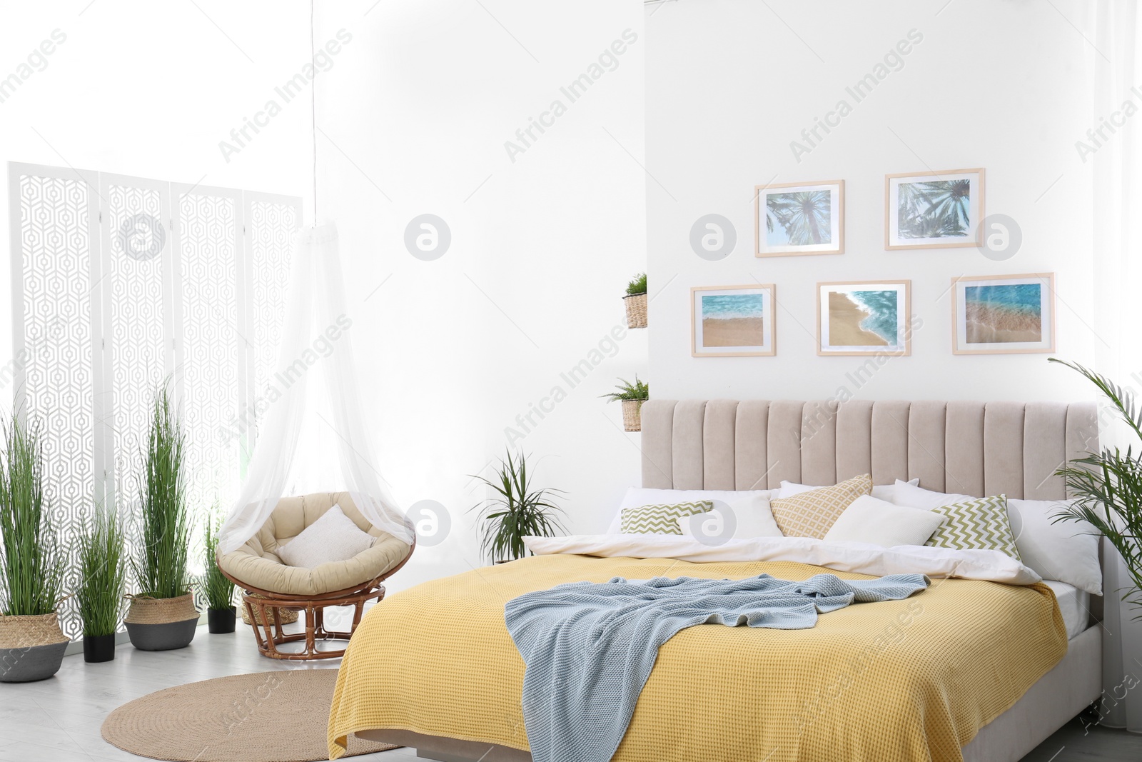 Photo of Stylish room interior with large comfortable bed and beautiful paintings