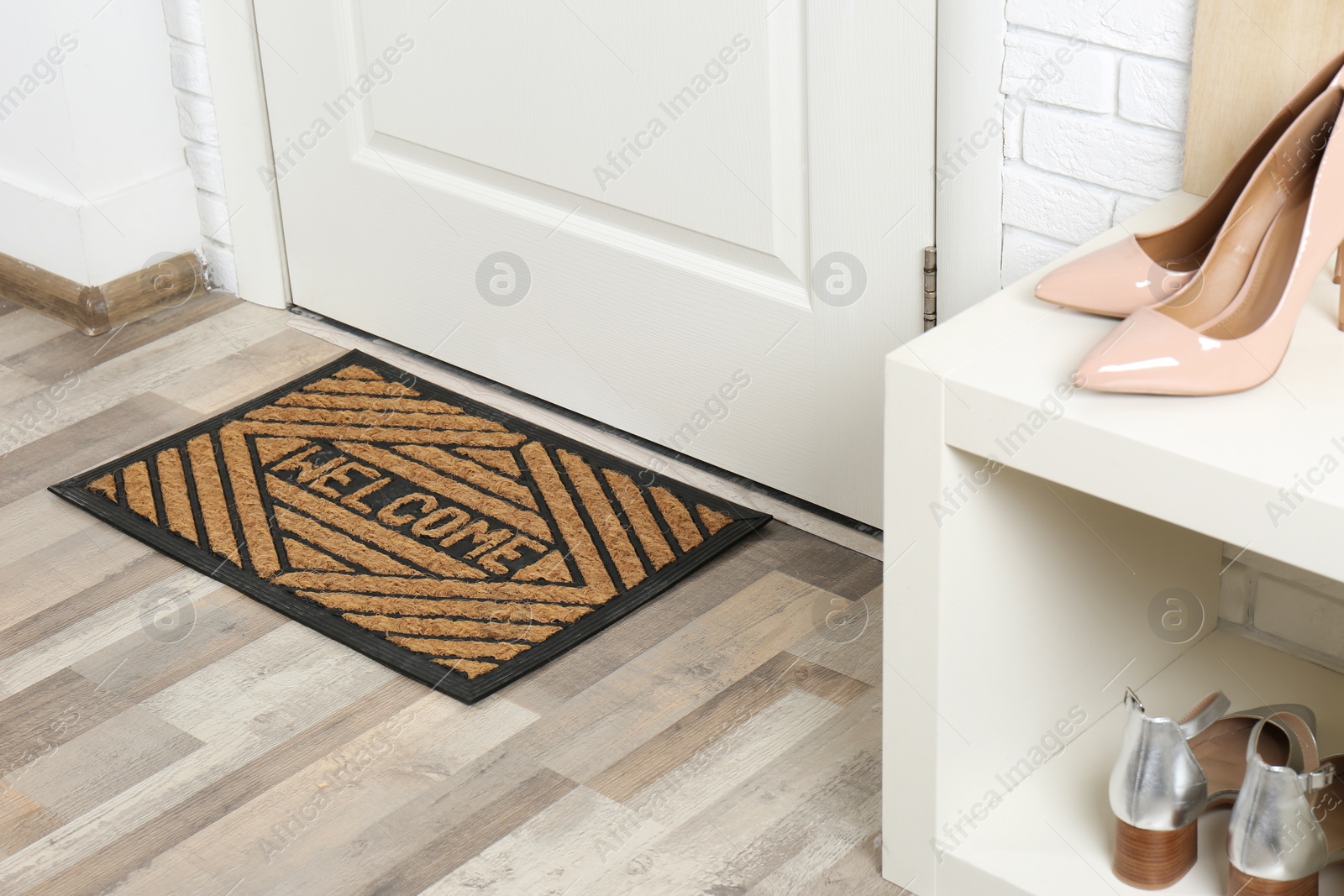 Photo of Shoe rack and mat near door in hallway