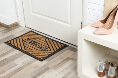 Shoe rack and mat near door in hallway