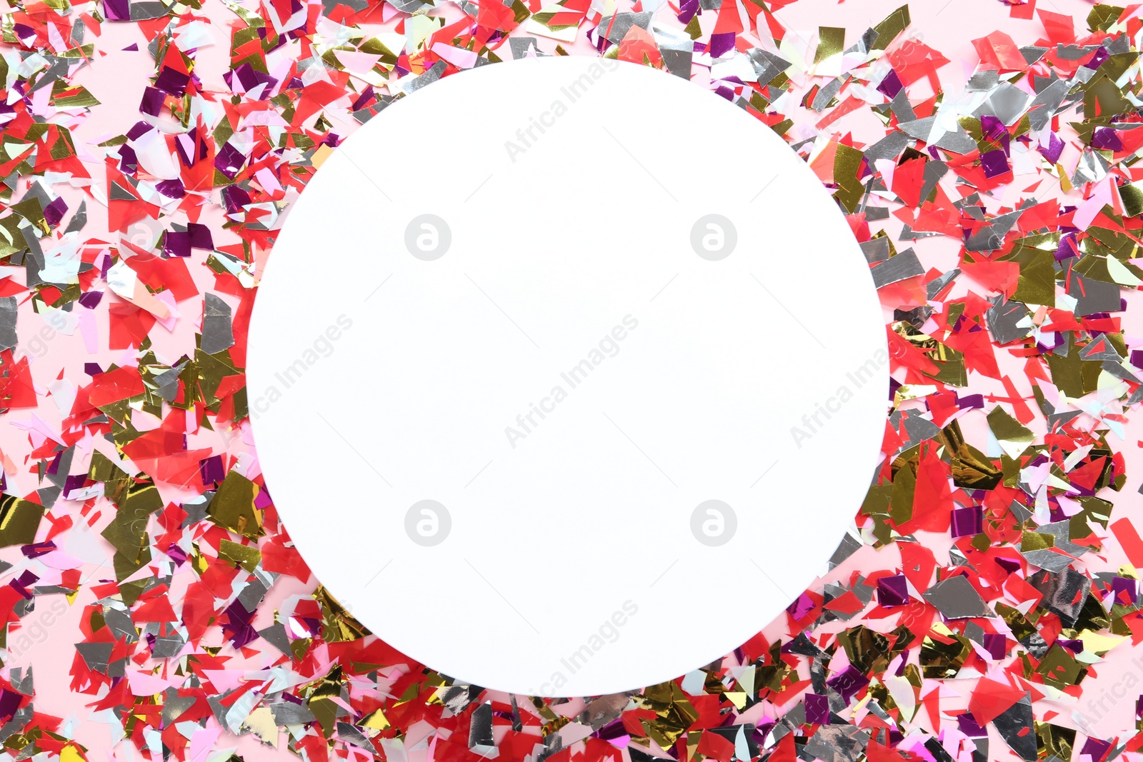 Photo of Frame of shiny colorful confetti on light background, flat lay. Space for text