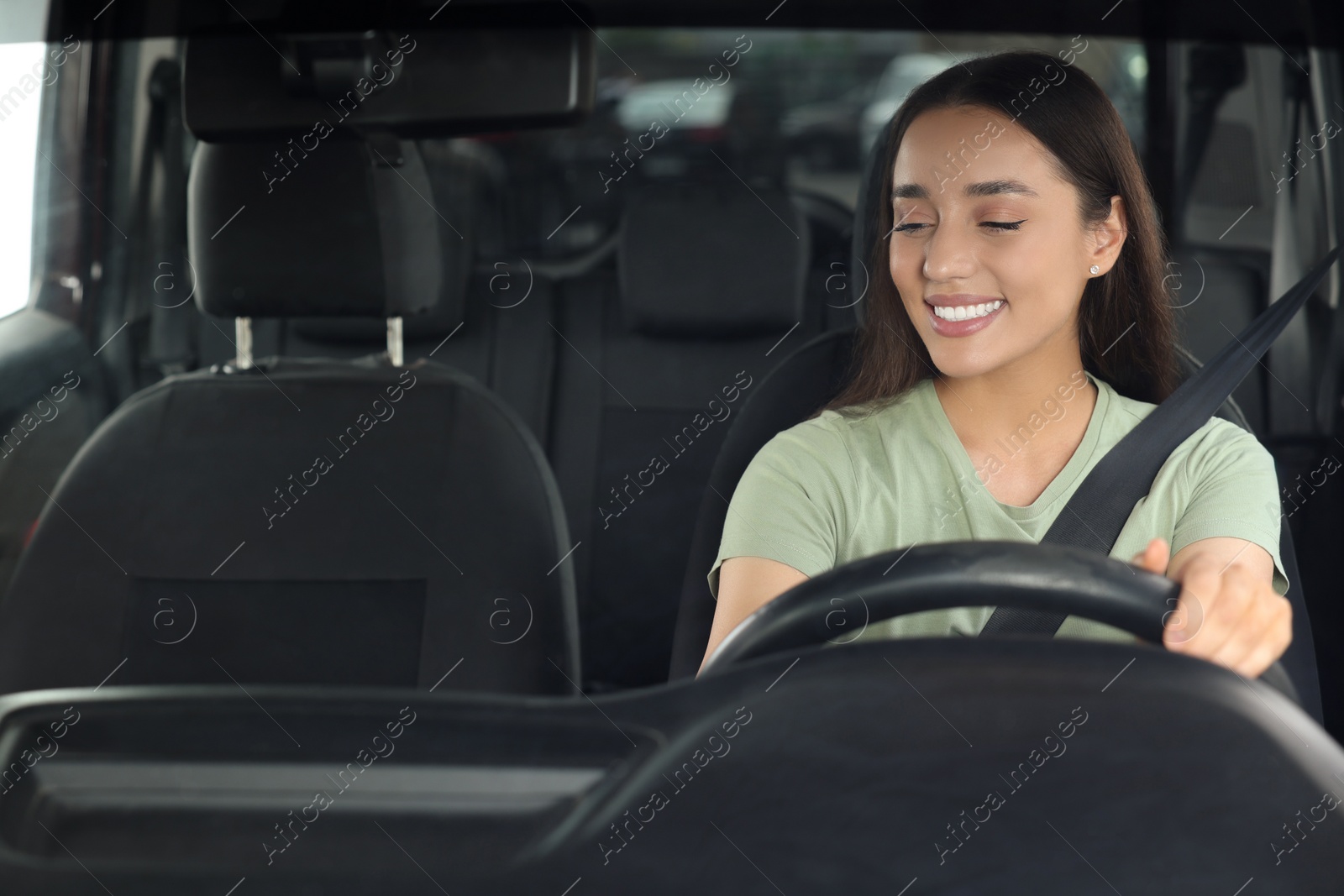 Photo of Listening to radio. Beautiful woman enjoying music in car, view through windshield