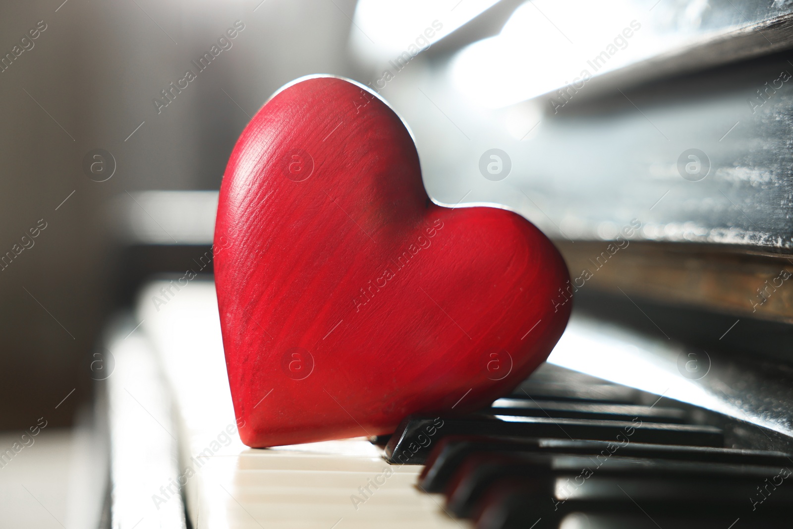 Photo of Red decorative heart on piano keys, closeup