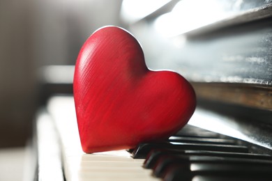 Photo of Red decorative heart on piano keys, closeup