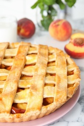 Photo of Delicious peach pie on white marble table, closeup