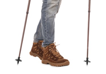 Man wearing stylish hiking boots with trekking poles on white background, closeup
