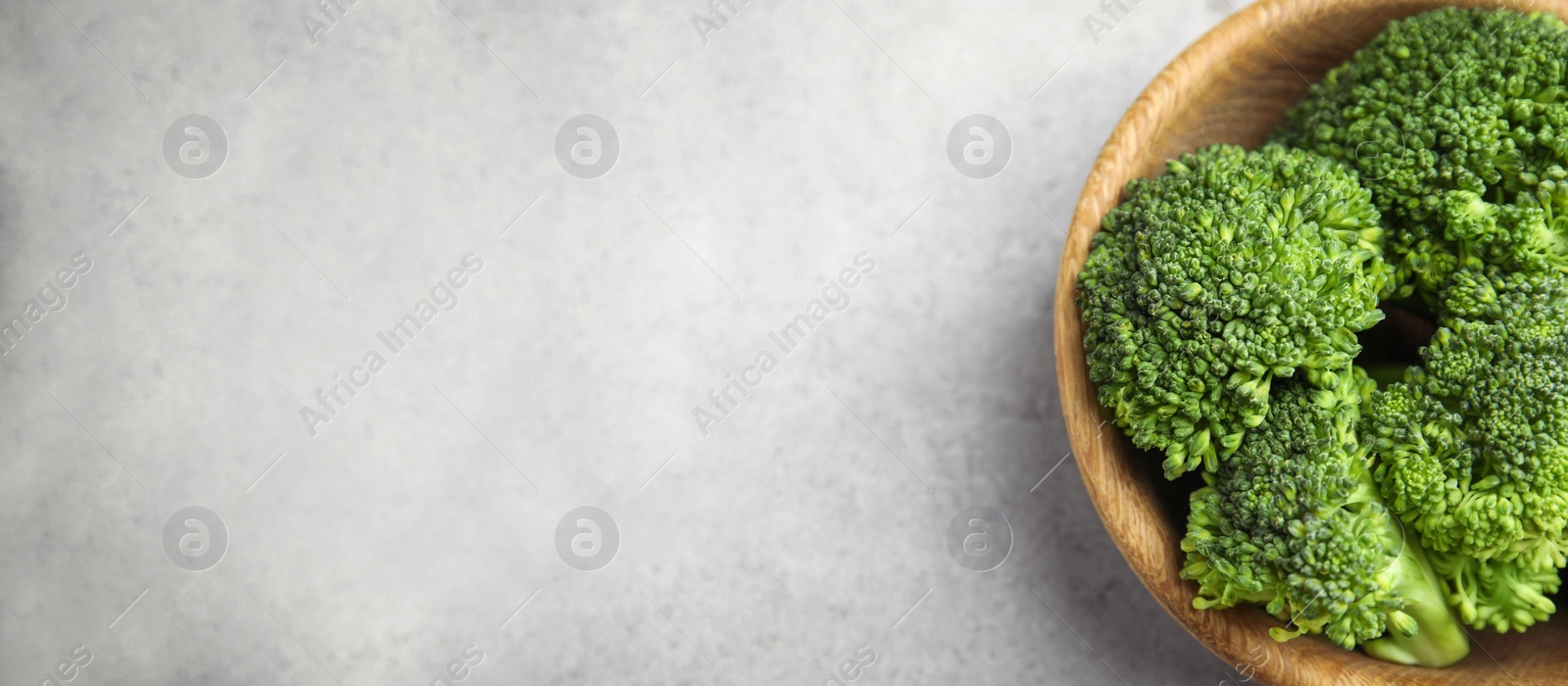 Image of Top view of fresh green broccoli on light marble table, space for text. Banner design 