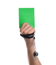 Football referee with whistle holding green card on white background, closeup