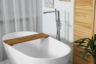 Photo of Stylish white tub in bathroom. Interior design