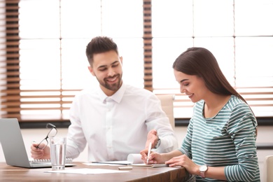 Insurance agent consulting young woman in office