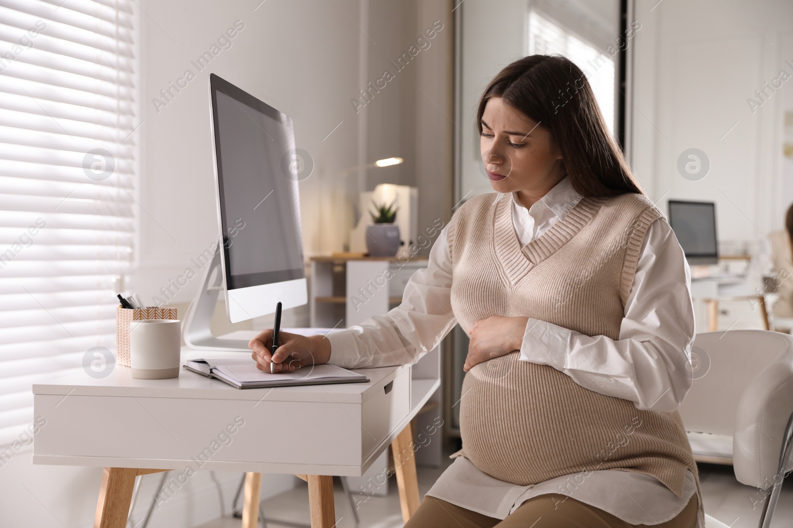 Photo of Tired pregnant woman working at home. Maternity leave