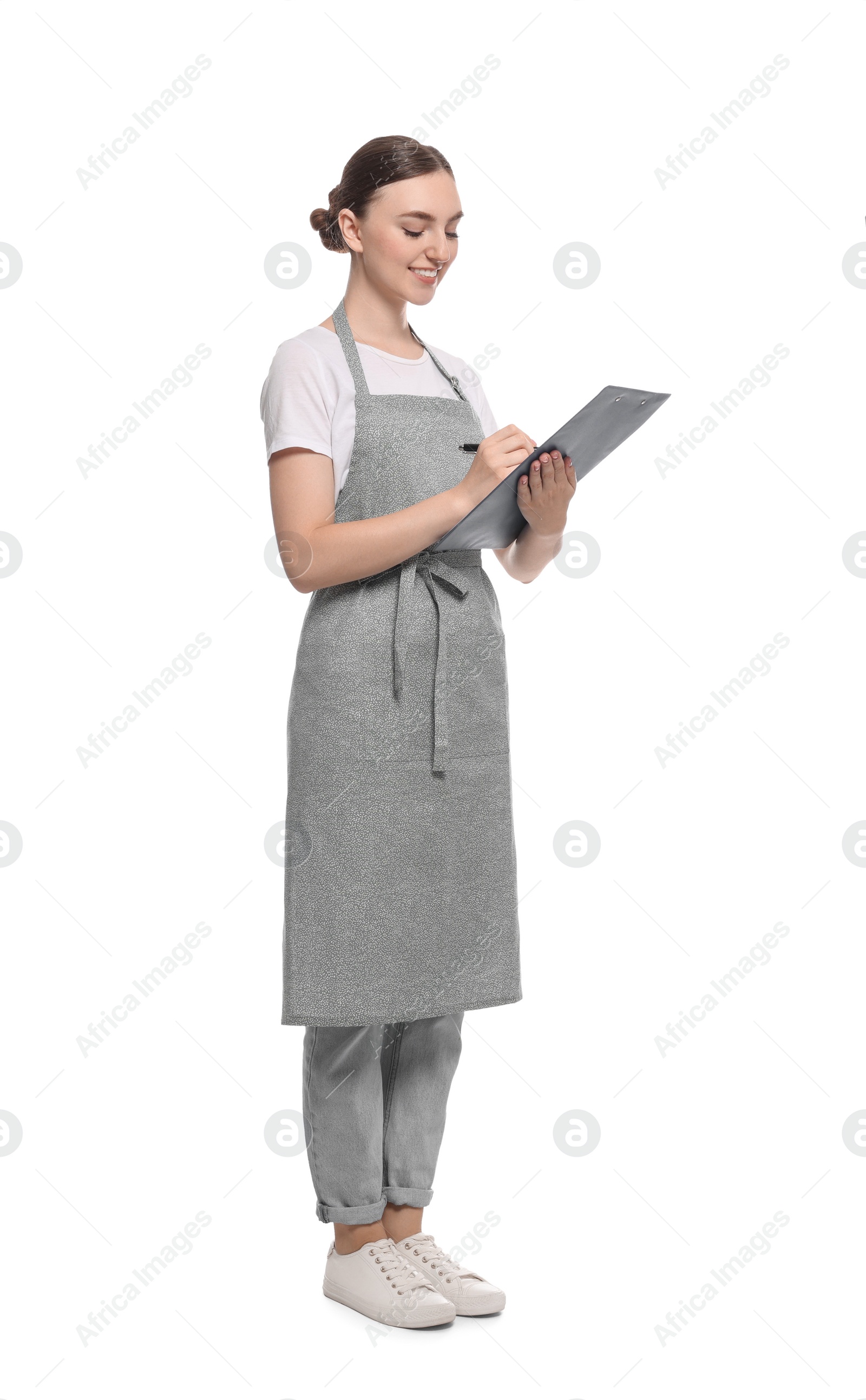 Photo of Beautiful young woman in clean apron with clipboard on white background