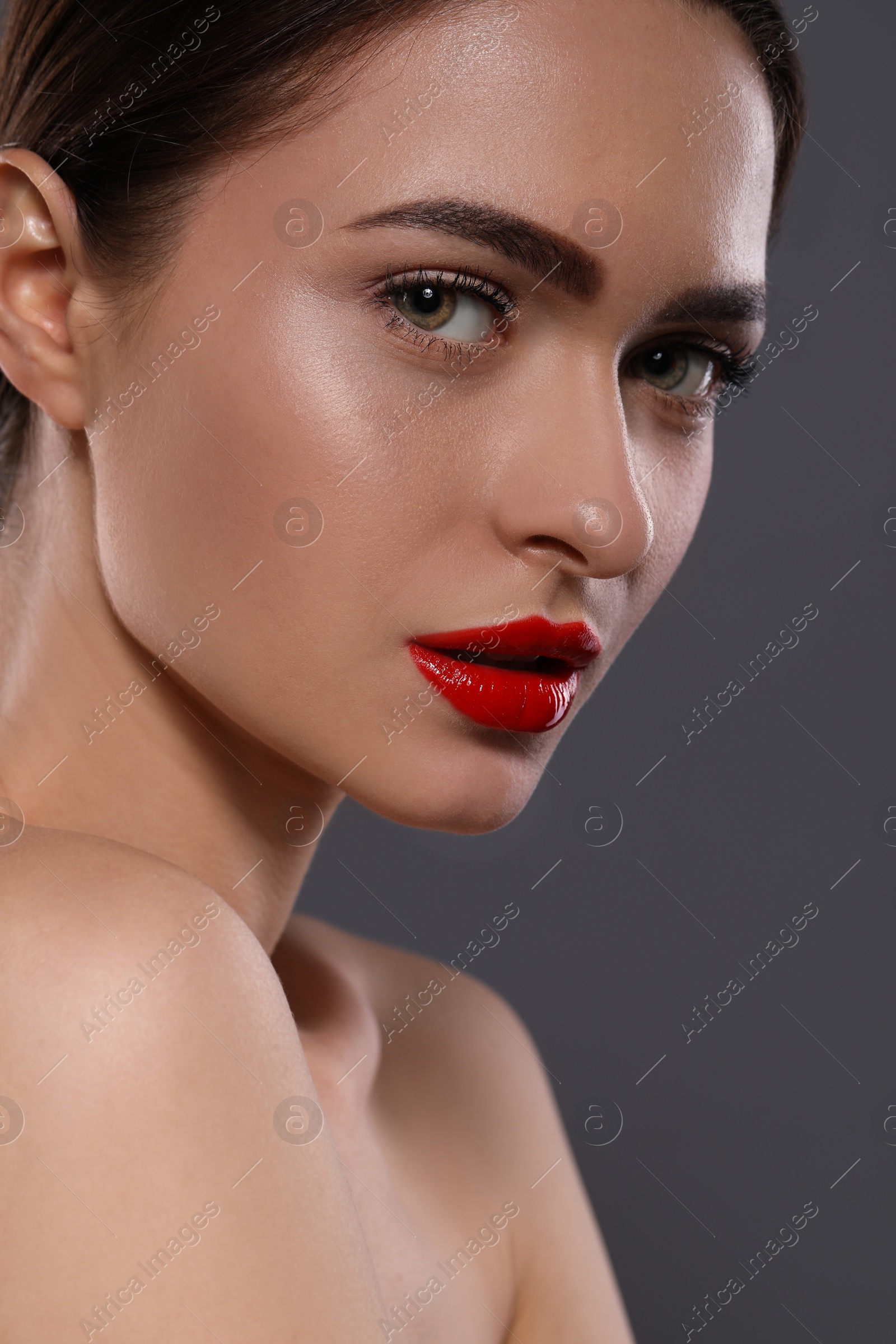 Photo of Young woman with red lips makeup on grey background