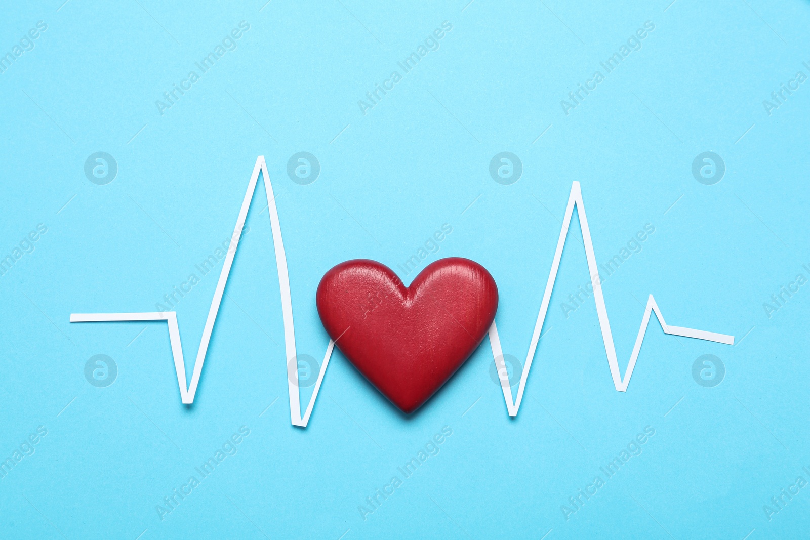 Photo of Paper cardiogram line and red heart on light blue background, flat lay