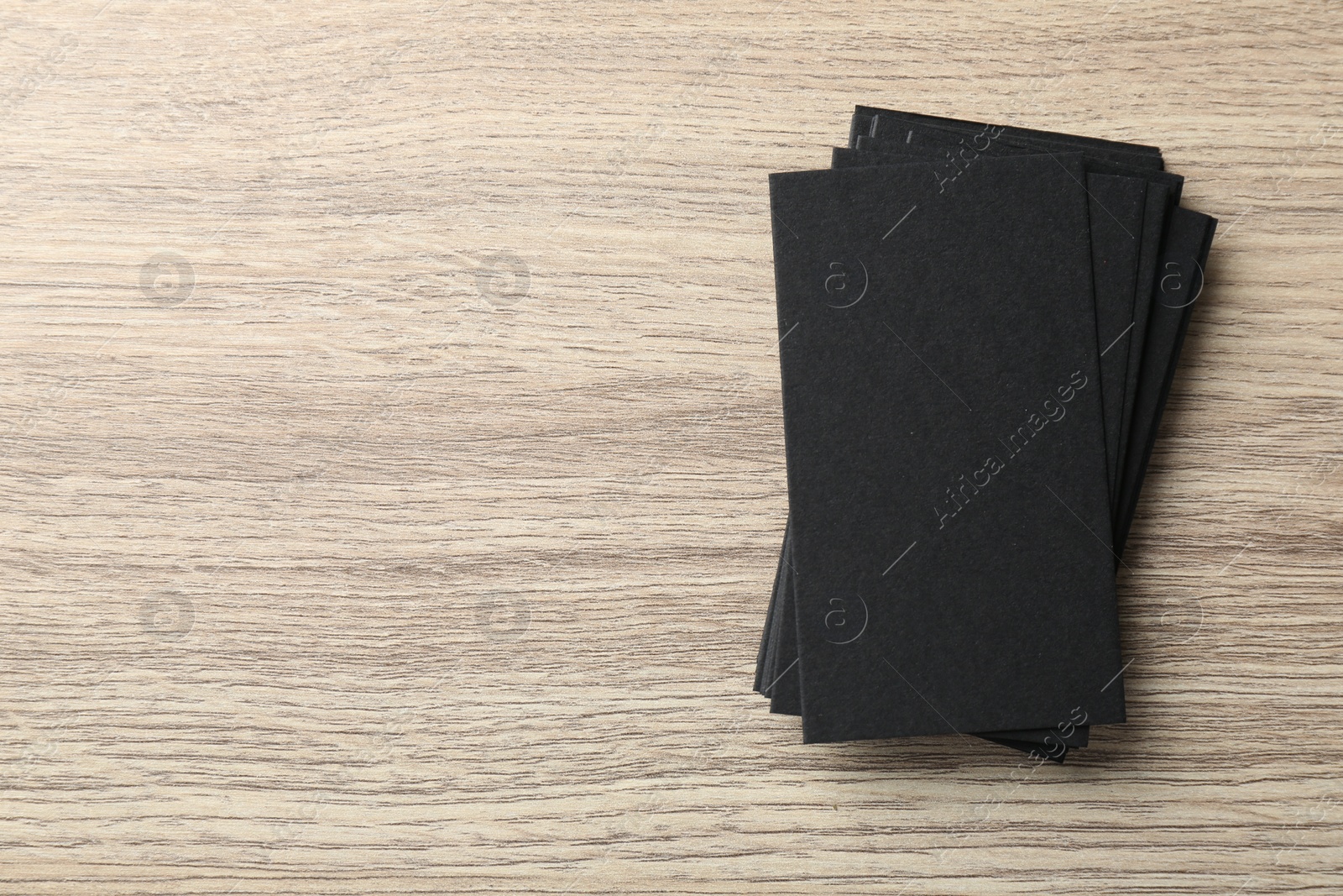 Photo of Blank black business cards on wooden table, top view. Mockup for design