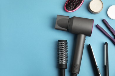 Photo of Flat lay composition with hairdressing equipment on light blue background. Space for text