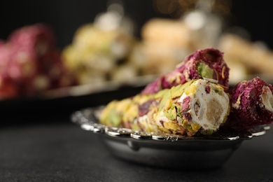 Photo of Tasty turkish delight dessert on dark table, closeup. Space for text