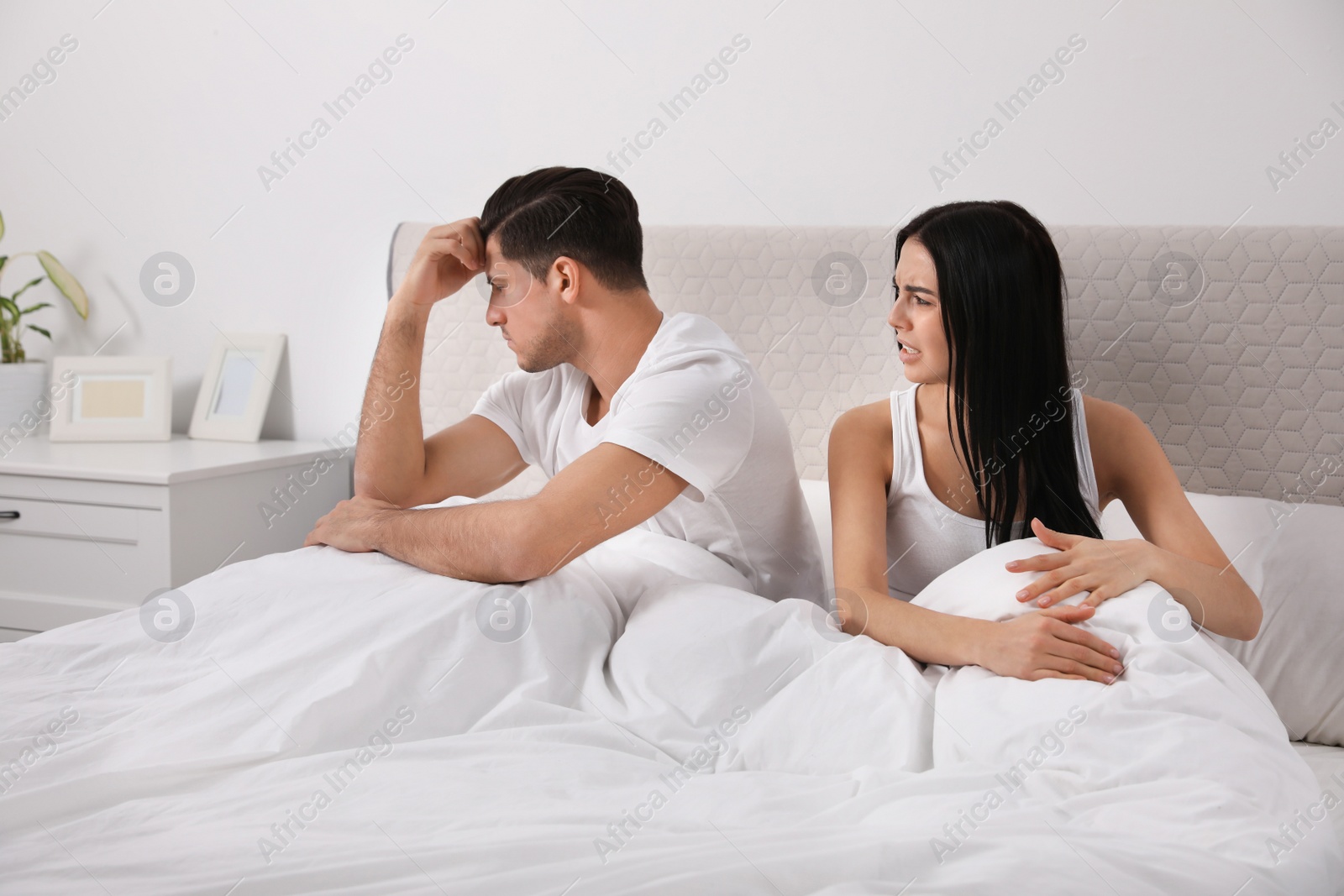 Photo of Unhappy couple with relationship problems after quarrel in bedroom