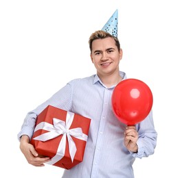 Young man with party hat, gift box and balloon on white background