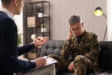 Professional psychotherapist working with military man in office