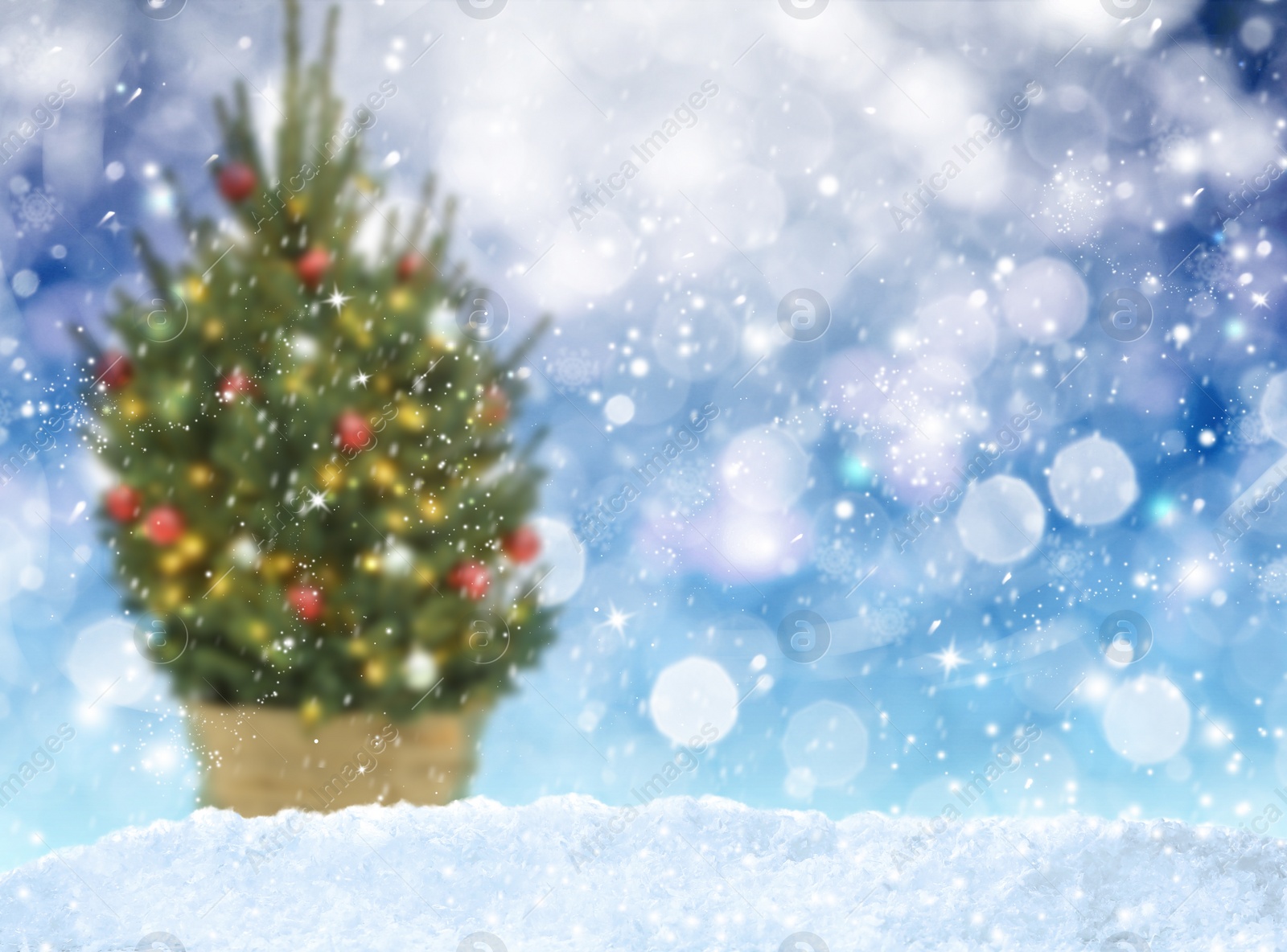 Image of Snow and blurred view of beautiful decorated Christmas tree. Bokeh effect