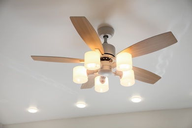 Modern ceiling fan with lamps indoors. Interior element