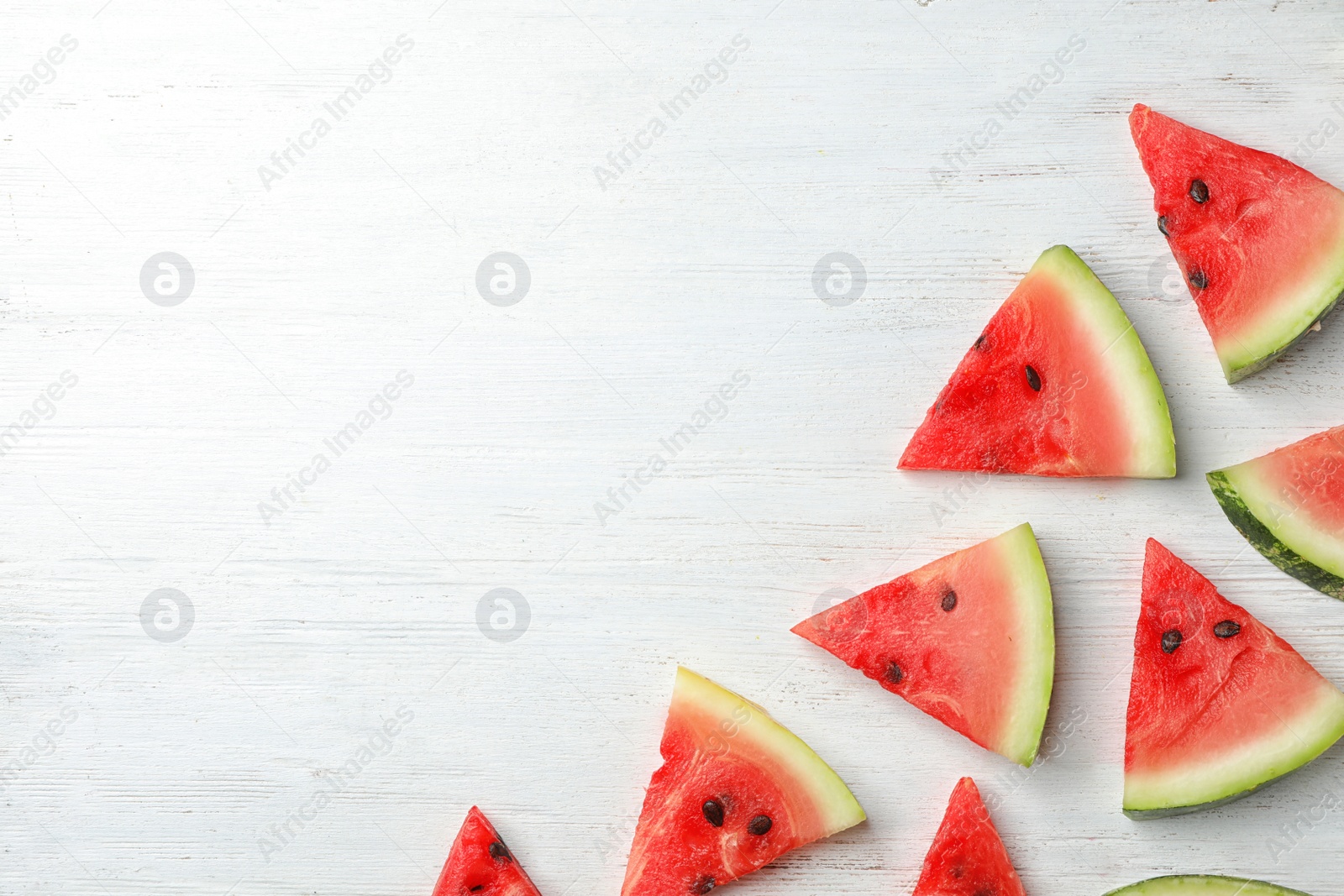 Photo of Slices of watermelon on wooden background, flat lay composition with space for text