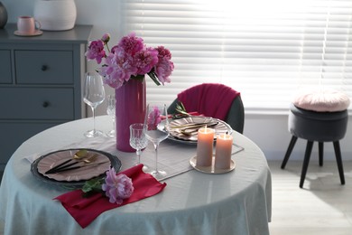 Photo of Beautiful table setting with pink peonies and burning candles