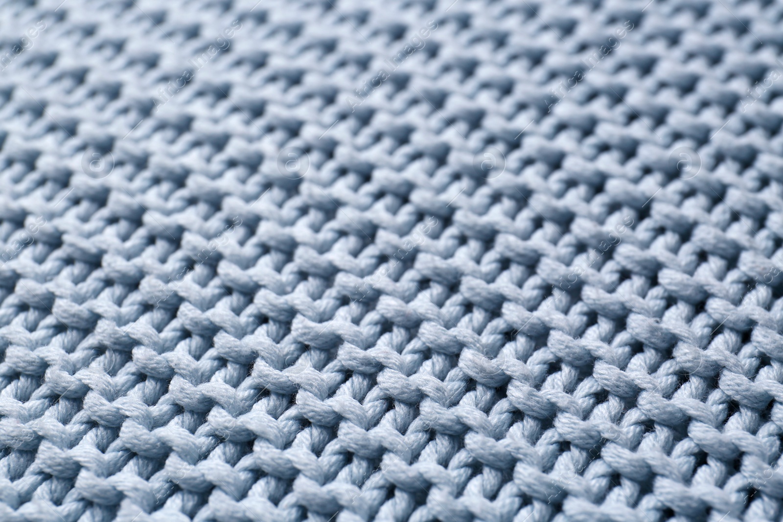 Photo of Beautiful light blue knitted fabric as background, closeup