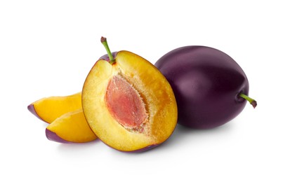 Whole and cut ripe plums on white background