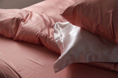 Photo of Closeup view of bed with beautiful silk linens