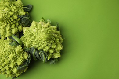 Photo of Fresh Romanesco broccoli on green background, flat lay. Space for text