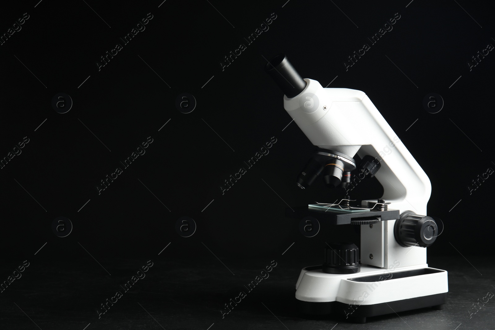 Photo of Modern microscope on black background, space for text. Medical equipment