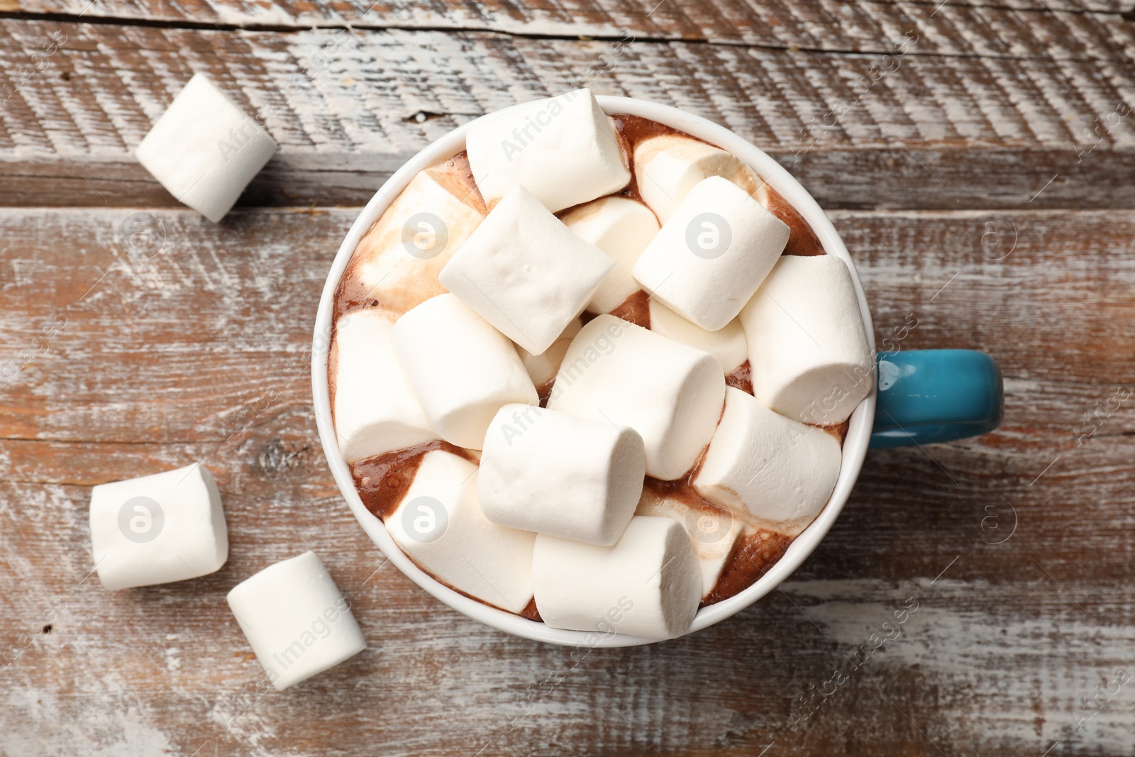 Photo of Tasty hot chocolate with marshmallows on wooden table, top view