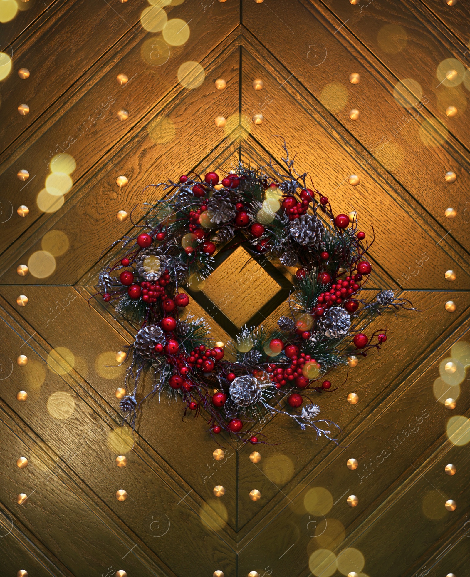 Photo of Beautiful Christmas wreath hanging on wooden door