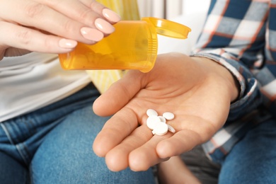 Woman giving medicine to man, closeup view