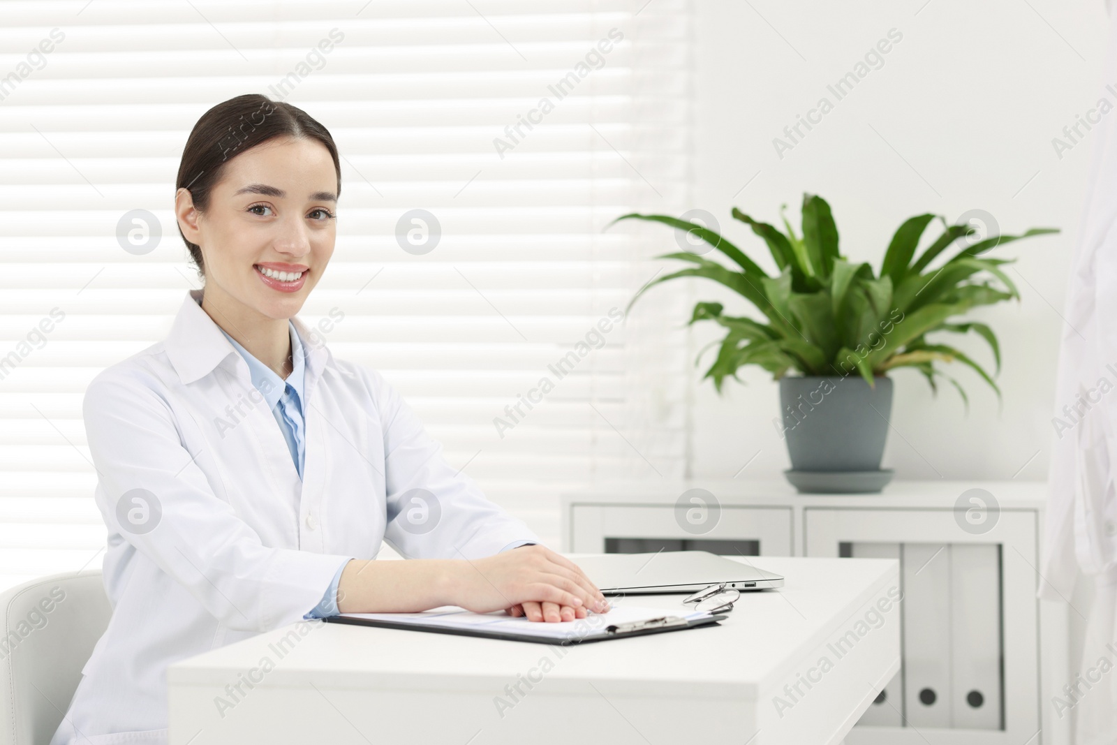 Photo of Medical consultant sitting at table in clinic