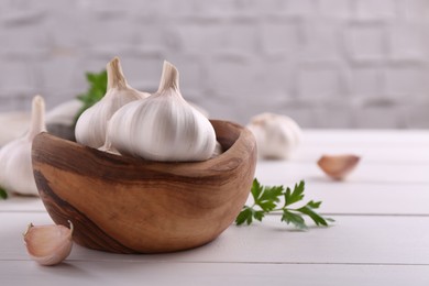 Photo of Fresh garlic on white wooden table, closeup. Space for text