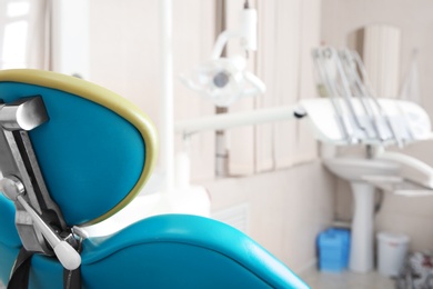 Photo of Empty chair in dentist's office, closeup view. Space for text