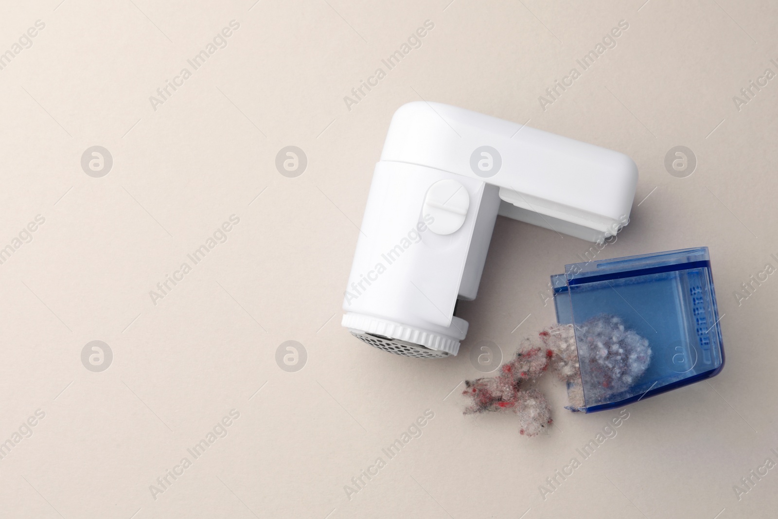 Photo of Modern fabric shaver with fuzz on white background, flat lay. Space for text