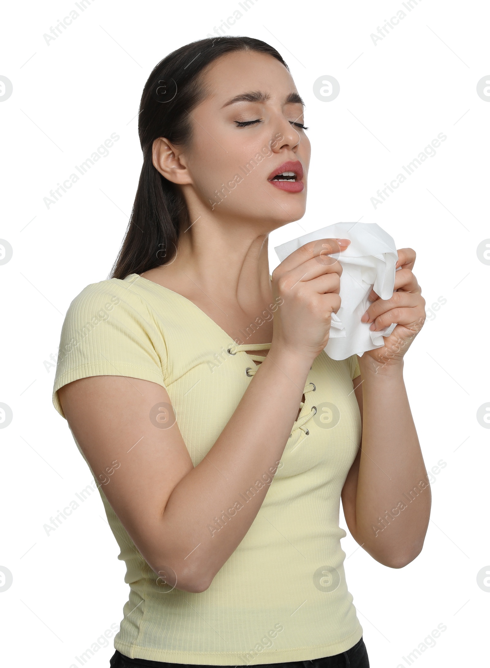 Photo of Sick young woman sneezing in tissue on white background. Cold symptoms