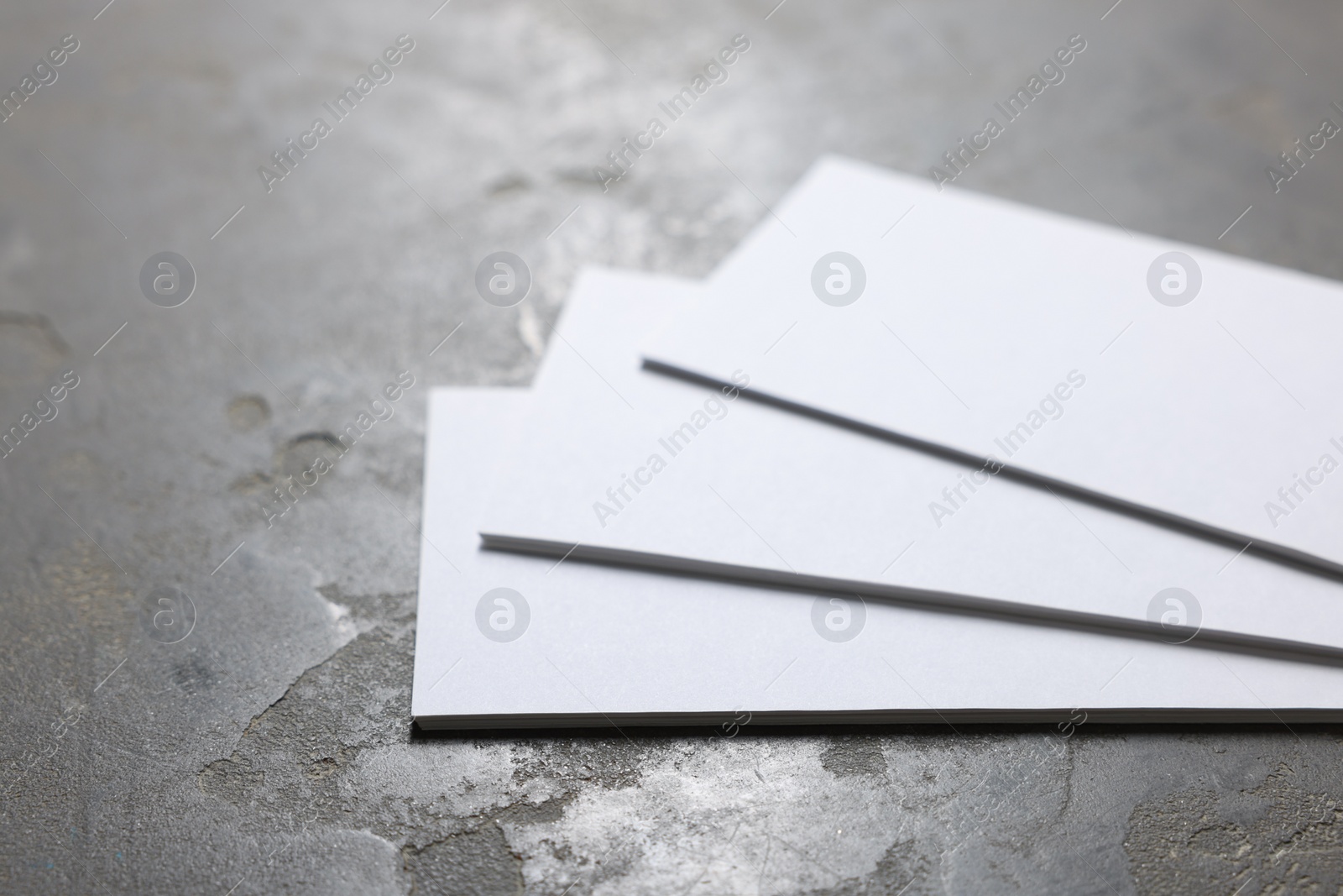 Photo of Blank business cards on grey textured background, closeup. Mockup for design