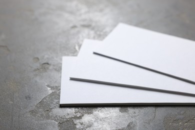 Photo of Blank business cards on grey textured background, closeup. Mockup for design