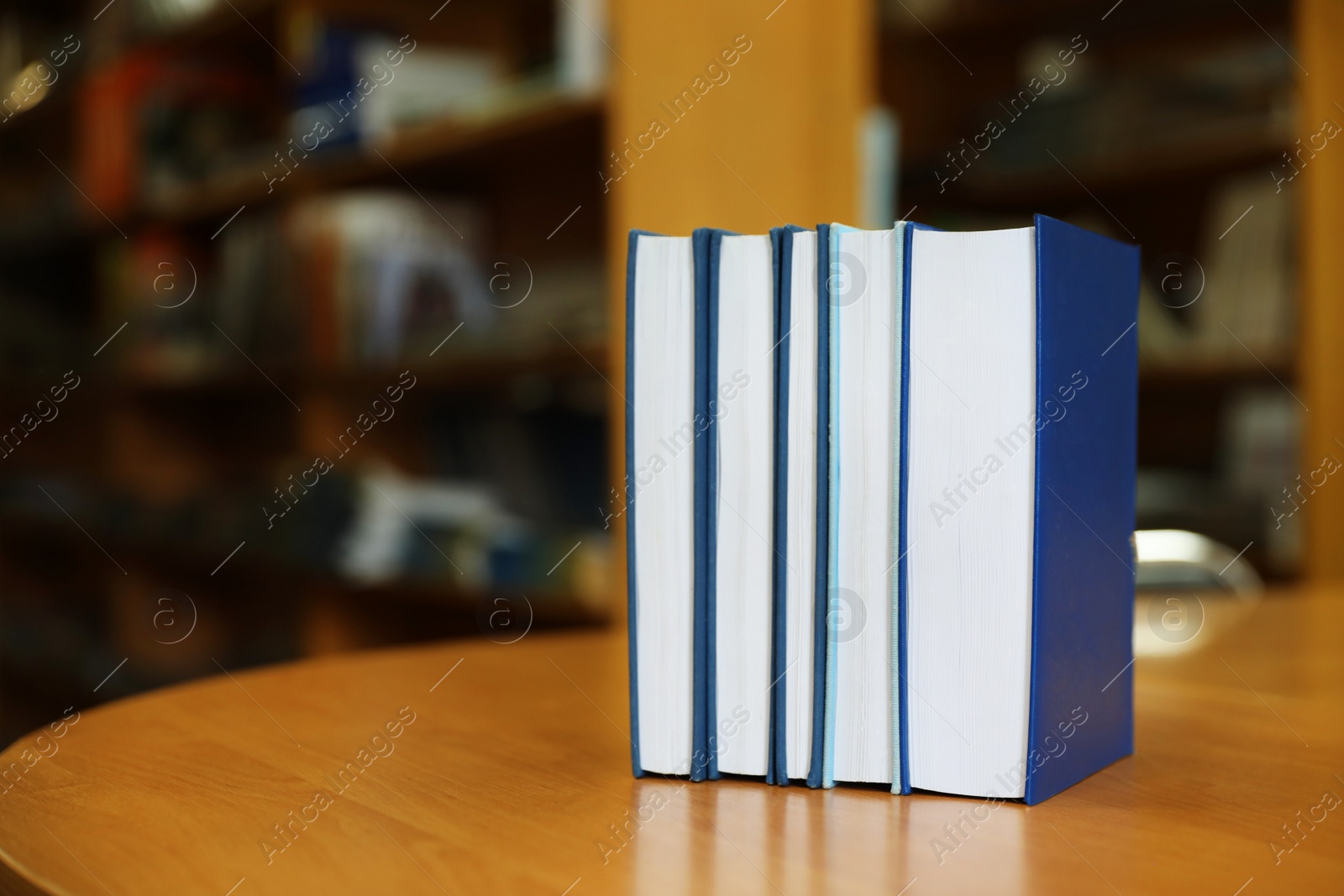 Photo of Books on table in library. Space for text