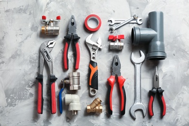 Photo of Flat lay composition with plumber's tools on grey background