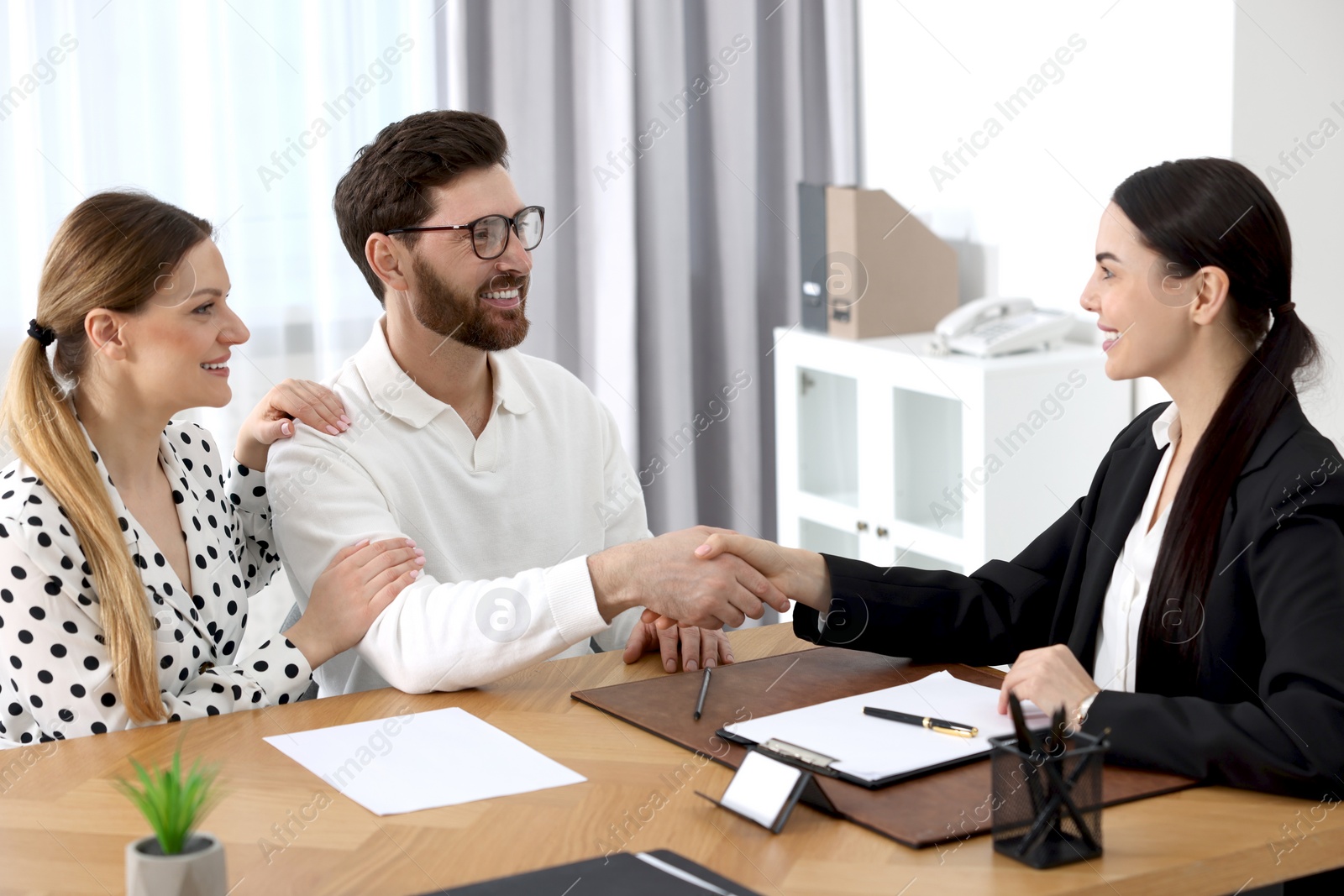 Photo of Lawyer shaking hands with clients in office