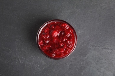 Bowl of cranberry sauce on grey background, top view