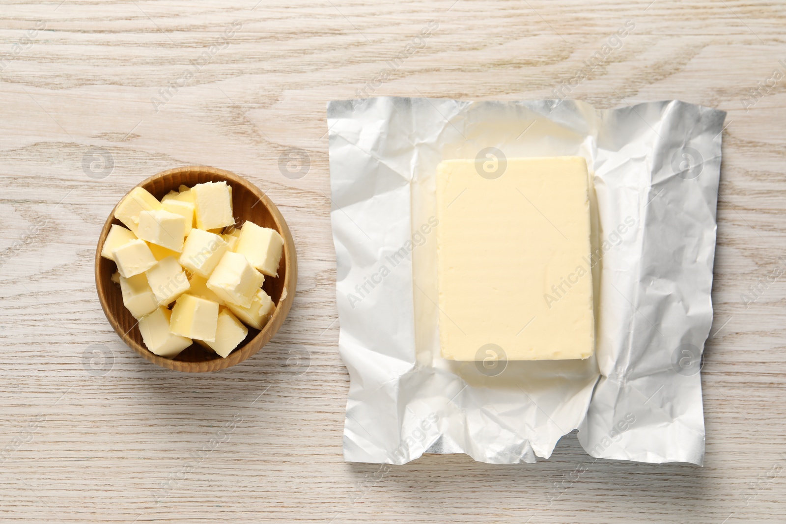 Photo of Tasty butter on light wooden table, flat lay