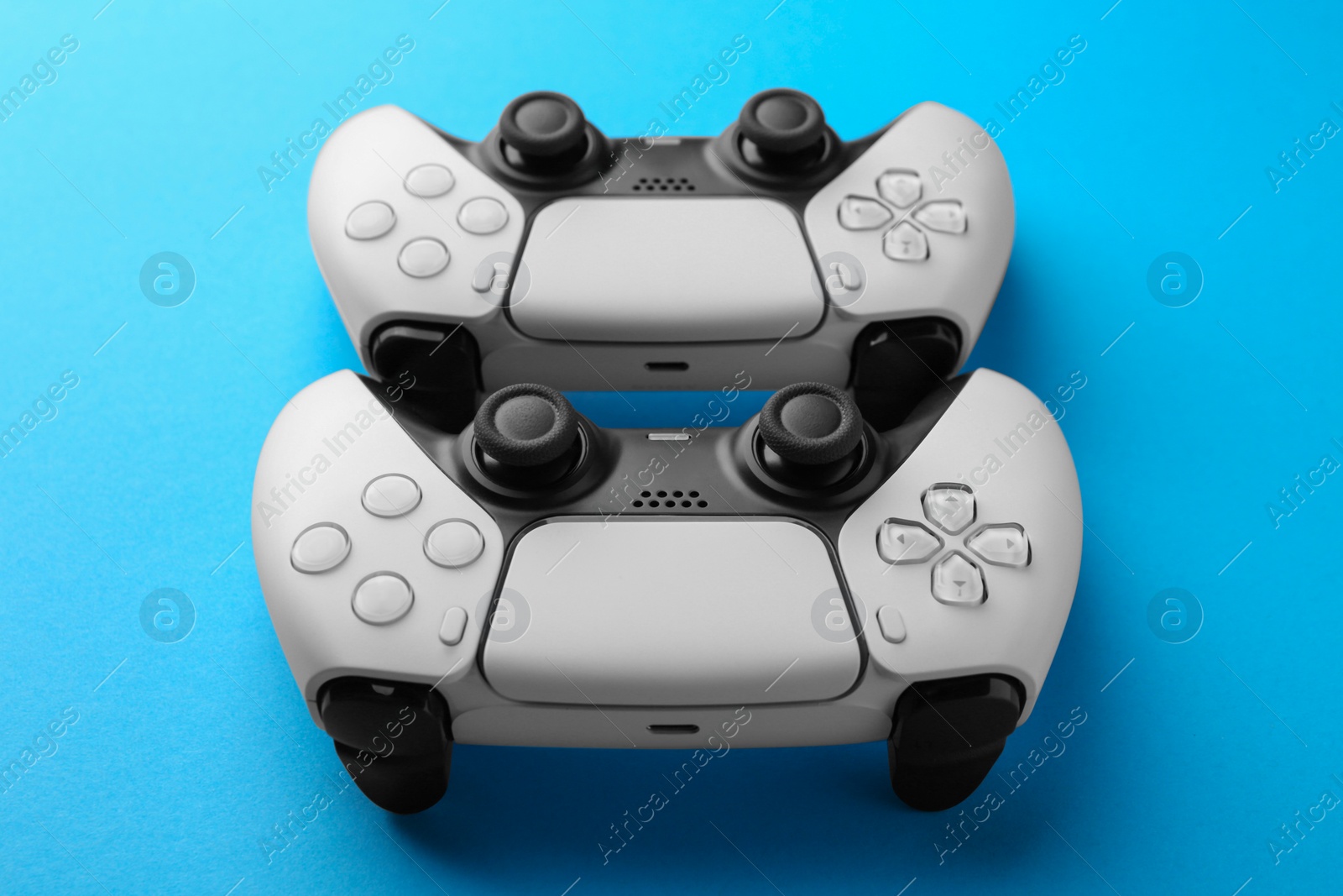 Photo of Wireless game controllers on light blue background